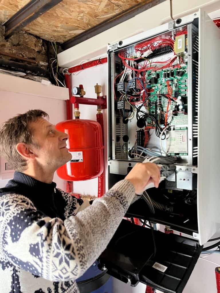 Technicien chauffagiste RGE Energoprime installant une pompe à chaleur air/eau Daikin en cascade en Île-de-France
