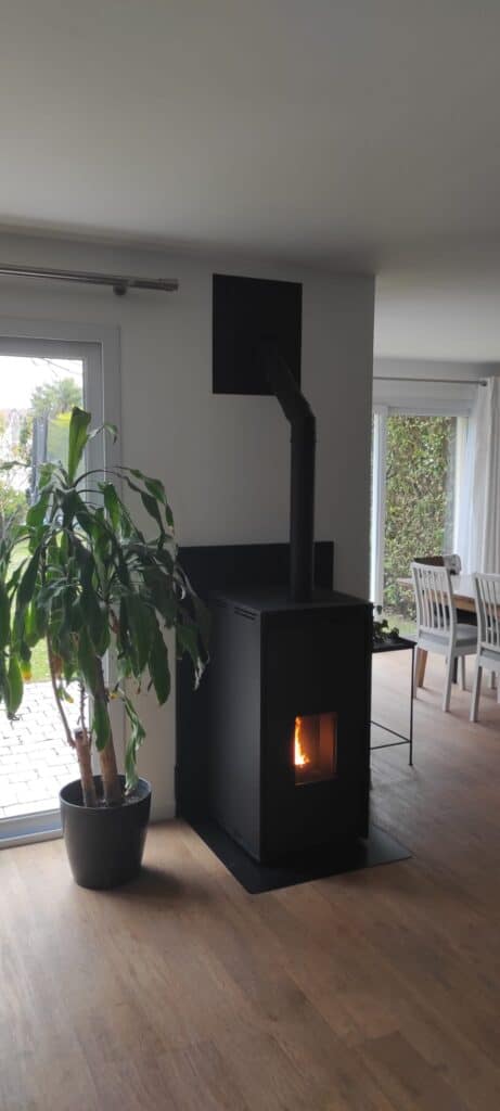 Poêle à bois installé dans salon – installation complète avec conduit de fumée intérieur – maison