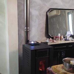 Poêle à granulés installé dans salon maison individuelle avec conduit intérieur