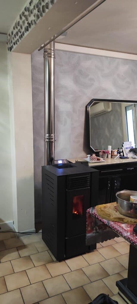 Poêle à granulés installé dans salon maison individuelle avec conduit intérieur