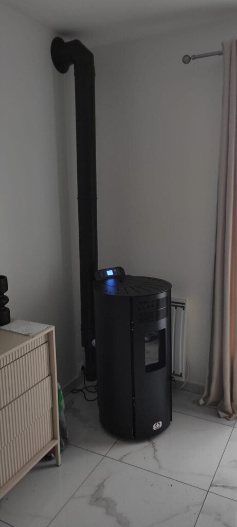 Poêle à granulés installé dans maison individuelle avec conduit intérieur