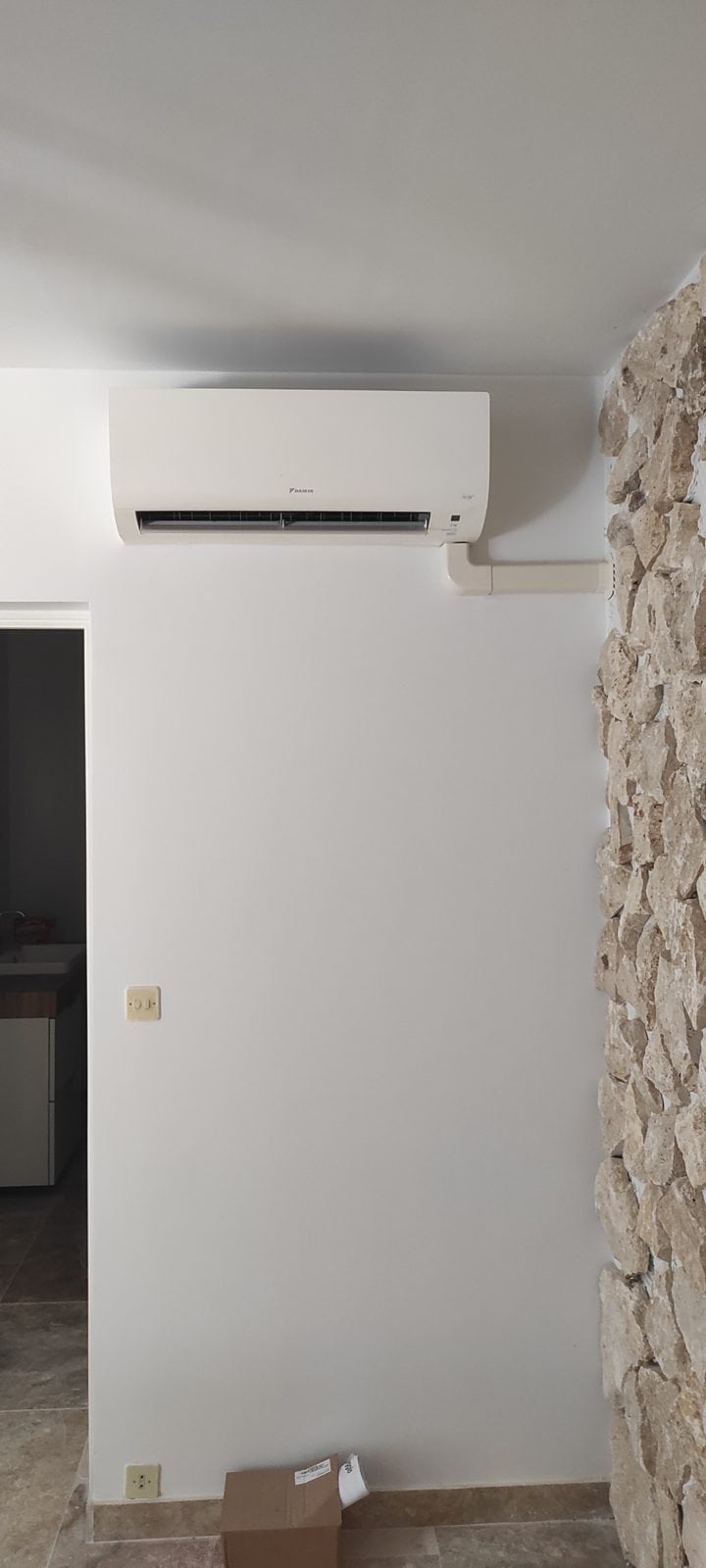 Unité intérieure Daikin dans une pièce avec mur en pierre apparente