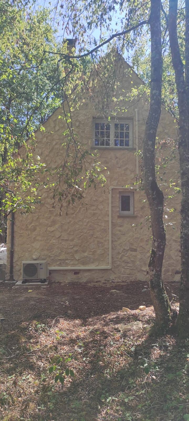 Maison en pierre avec groupe extérieur de climatisation Daikin discret en façade