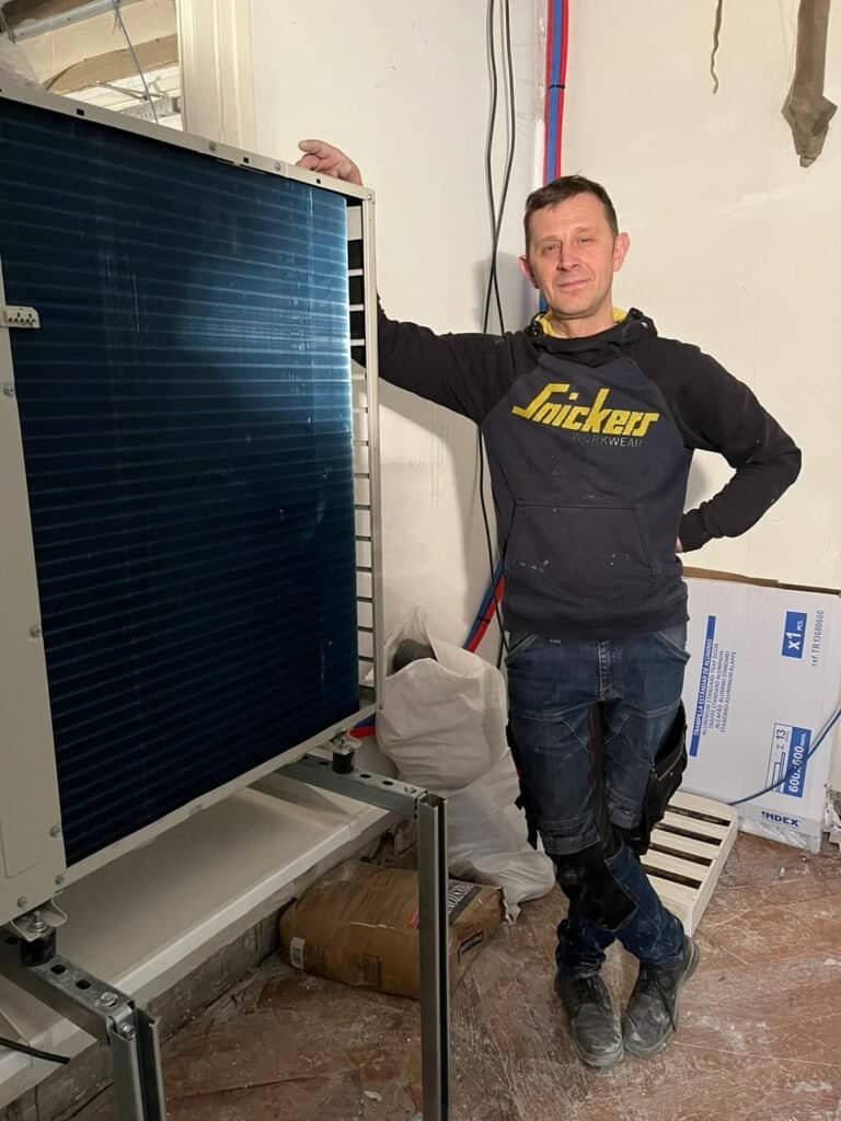 Installateur EnergoPrime à côté d’une unité extérieure de pompe à chaleur en cours d’installation