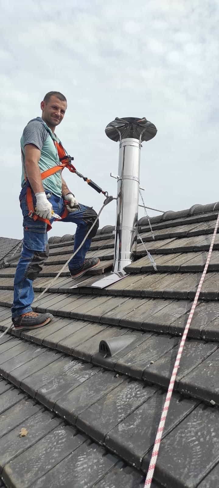 Technicien EnergoPrime harnaché sur un toit, pose d’un conduit de fumée inox double paroi avec sortie en toiture