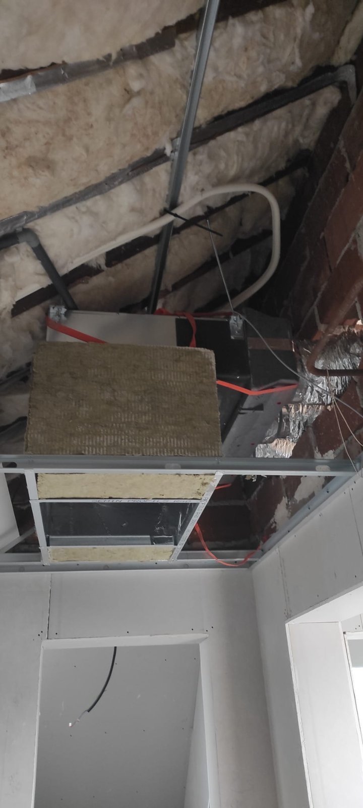 Unité intérieure gainable Mitsubishi Electric PEAD-M suspendue dans le faux plafond, avec isolation en laine de roche
